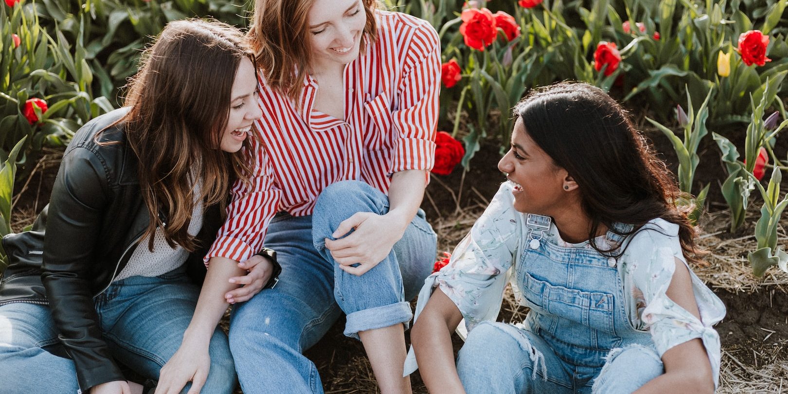 three woman sitting near the flower